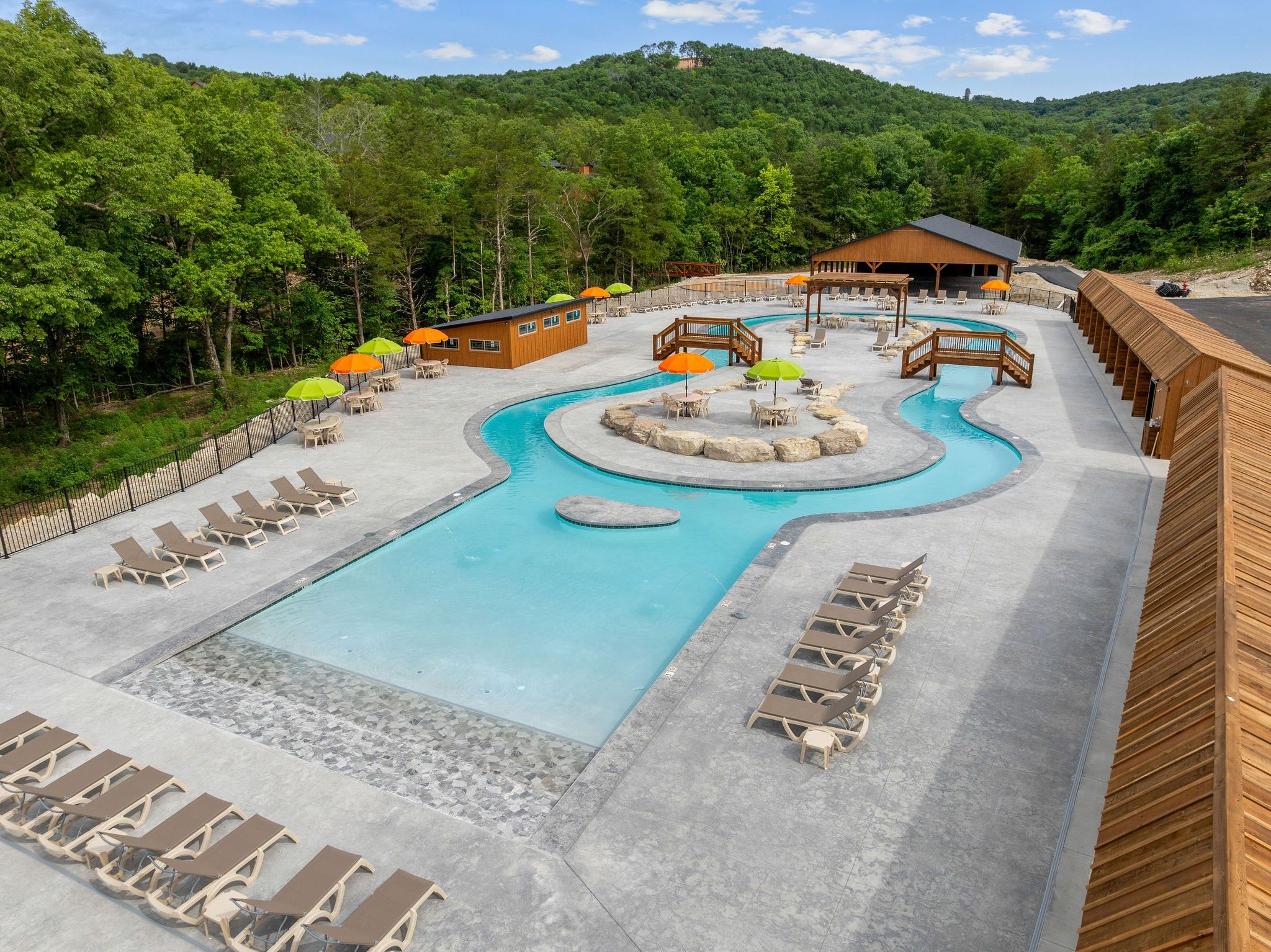 A resort with a pool, lounge chairs, and a wooden building.