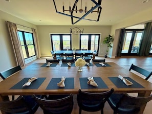 A dining room with a large table, chairs, and a chandelier. - Bourbon Lounge • Hot Tub + Firepit • Arcade (Bardstown)