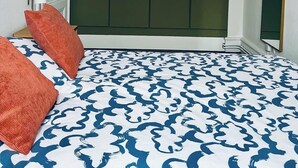 Un dormitorio con cama, armario y lámpara colgante.