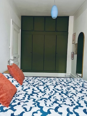 Ein Schlafzimmer mit einem Bett, einem Kleiderschrank und einer Pendelleuchte.