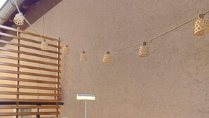 An outdoor patio with a white table, striped chairs, a lamp, and string lights. - Studio cocooning à 5km du centre de Strasbourg (Schiltigheim)