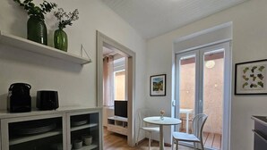 A compact kitchen with a dining area, a TV, and a window with a view. - Studio cocooning à 5km du centre de Strasbourg (Schiltigheim)