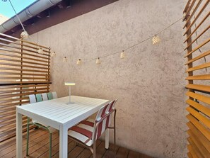 An outdoor patio with a white table and chairs, string lights, and a lamp. - Studio cocooning à 5km du centre de Strasbourg (Schiltigheim)