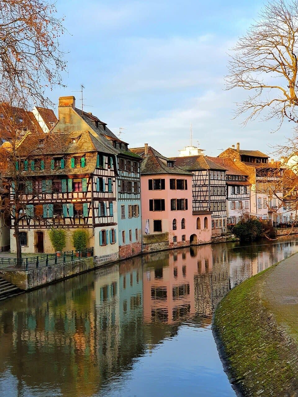 Un canal où les bâtiments se reflètent dans l’eau.