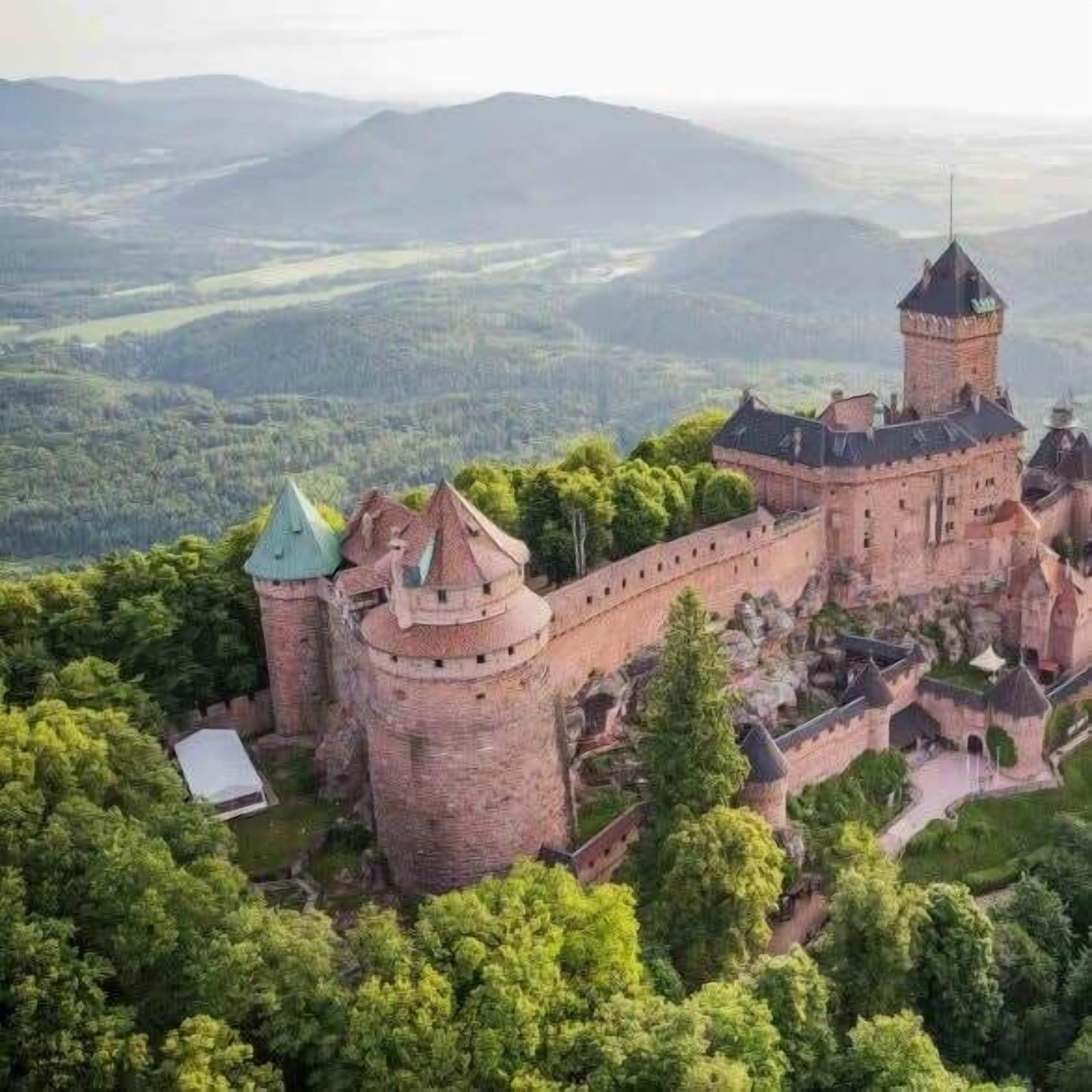 Un château entouré d’une végétation luxuriante et de collines.