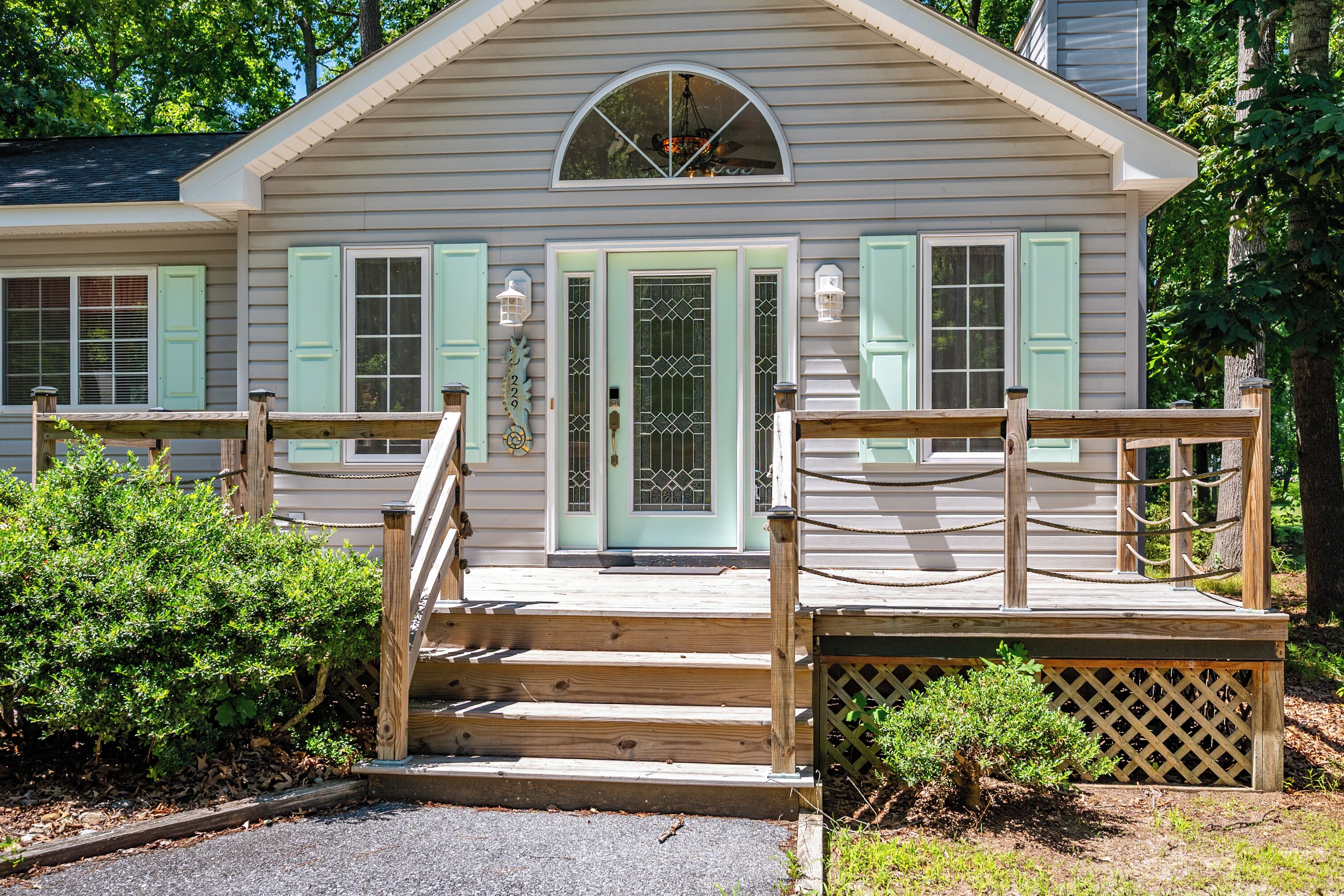 A two-story house with a wooden front porch, a mailbox, and a mailbox number.