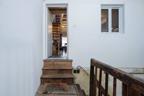 A staircase leading to a room with a wooden door and a window. - Beautiful apartment in the heart of Annecy (Annecy)