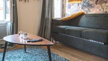 A cozy living room with a sofa, a coffee table, and a patterned rug.