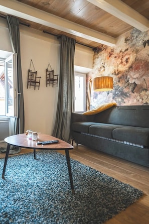 A cozy living room with a sofa, a coffee table, and a patterned rug.