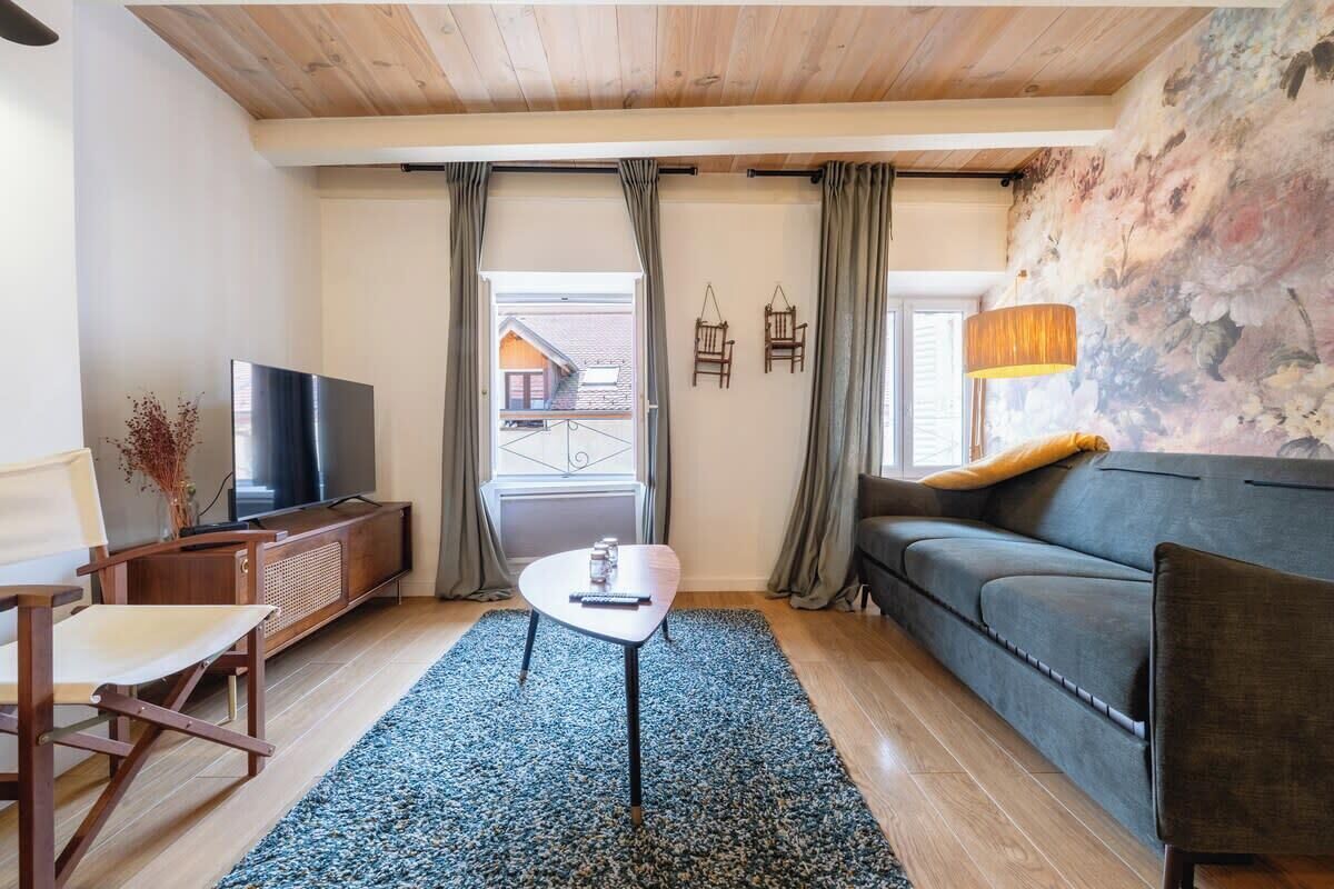 A living room with a television, sofa, and a small table.