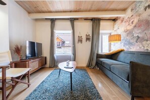 A living room with a television, sofa, and a small table. - Beautiful apartment in the heart of Annecy (Annecy)