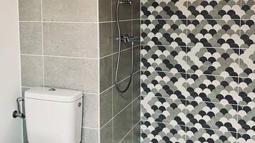 Une salle de bain avec des toilettes, une douche et un lavabo.
