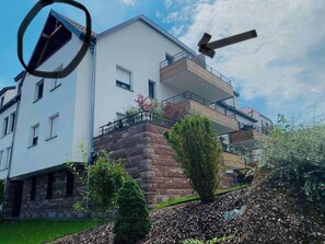 A modern two-story building with a balcony, a stone base, and a clear sky. - Sublime Studio, 2 terrasses + vue sur le vignoble (Rosheim)