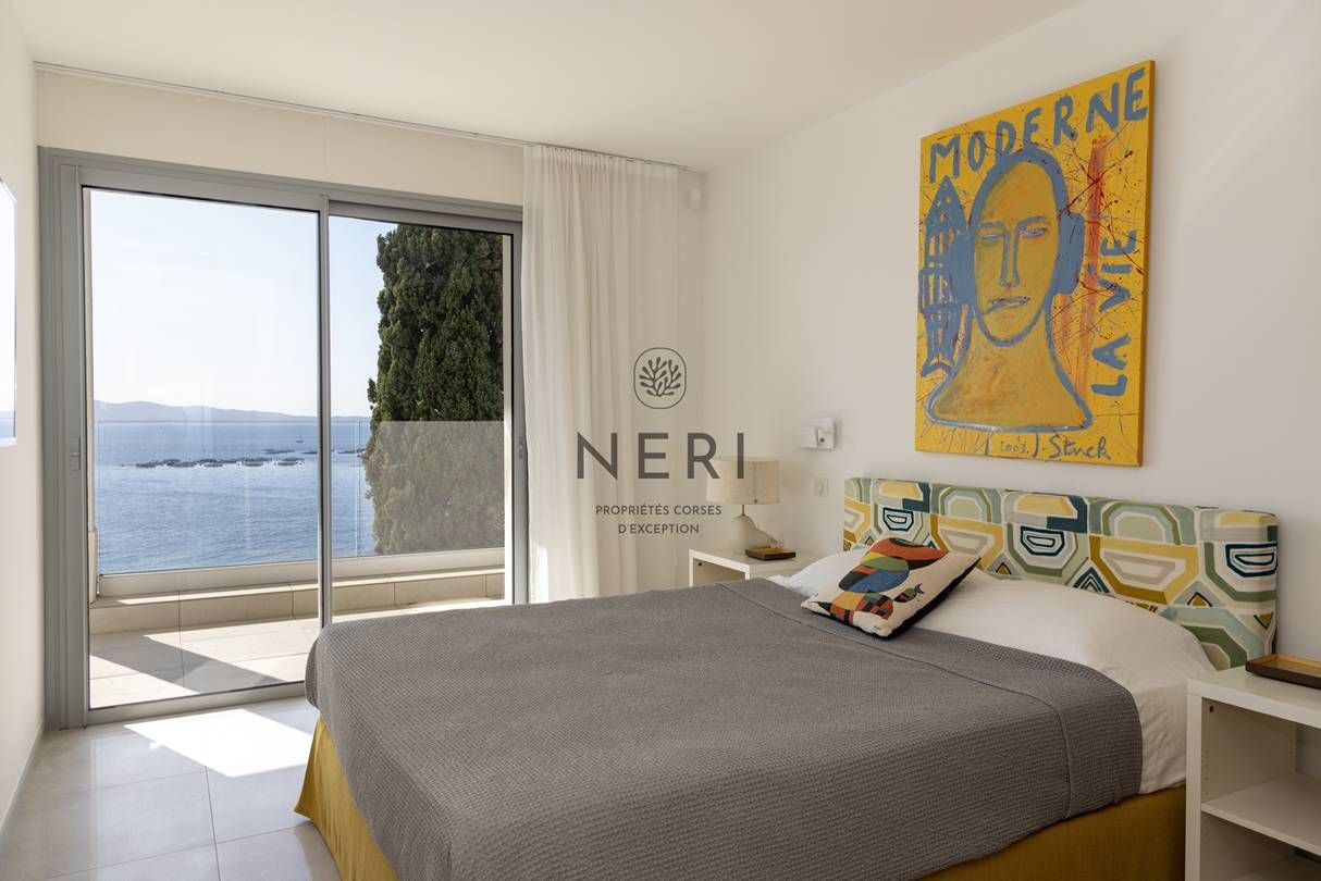Une chambre d’hôtel avec un lit, une grande fenêtre et un tableau au mur.