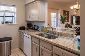 A modern kitchen with granite countertops, stainless steel appliances, and a built-in dishwasher. - Cute Condo with Pool View and lots of charm! (Houston)