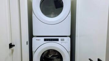 Uma lavanderia compacta com duas máquinas de lavar Whirlpool empilhadas.
