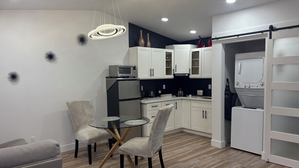 A modern kitchen with white cabinets, a microwave, and a washing machine. - Beautiful Guesthouse in Kierland. Studio A (Scottsdale)
