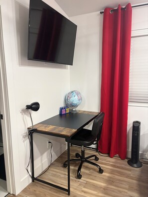 A room with a desk, chair, globe, and a TV mounted on the wall. - Beautiful Guesthouse in Kierland. Studio A (Scottsdale)