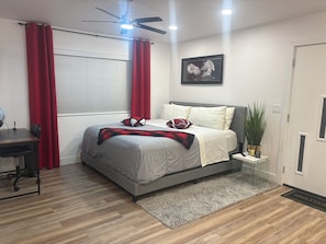 A bedroom with a bed, a desk, a chair, a ceiling fan, and a window with blinds. - Beautiful Guesthouse in Kierland. Studio A (Scottsdale)