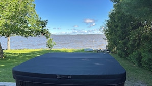 Uma banheira de hidromassagem com vista para um lago e árvores.