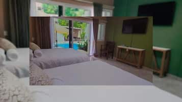 A hotel room with two beds, a desk, and a TV.