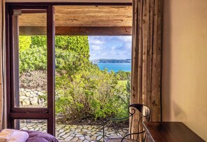 Ein Zimmer mit Blick auf einen Garten und ein Gewässer.