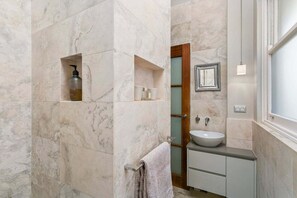 A bathroom with marble walls, a built-in sink, and a towel rack. - WAV64 - Charming Waverton Escape | Top-Floor 2-Bed With City & Harbour Views (Waverton)
