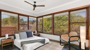 A bedroom with a bed, a nightstand, a chair, and a ceiling fan. - WAV64 - Charming Waverton Escape | Top-Floor 2-Bed With City & Harbour Views (Waverton)