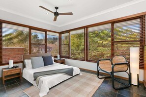 A bedroom with a bed, a nightstand, a chair, and a ceiling fan. - WAV64 - Charming Waverton Escape | Top-Floor 2-Bed With City & Harbour Views (Waverton)