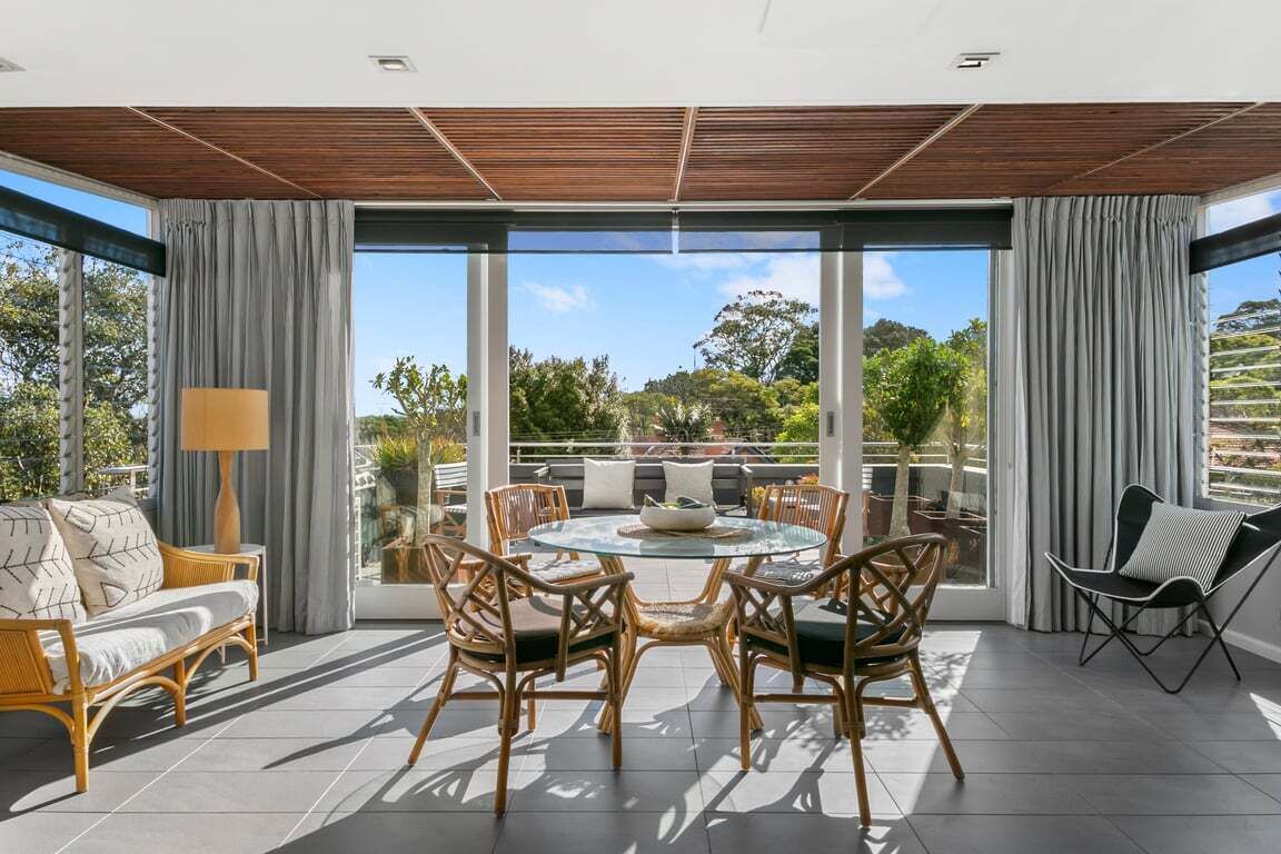 A spacious outdoor area with a round table and chairs, a sofa, and a chair.