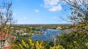 A coastal town with a marina, buildings, and a bridge in the distance. - WAV64 - Charming Waverton Escape | Top-Floor 2-Bed With City & Harbour Views (Waverton)