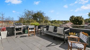 An outdoor patio with a grill, seating area, and potted plants. - WAV64 - Charming Waverton Escape | Top-Floor 2-Bed With City & Harbour Views (Waverton)