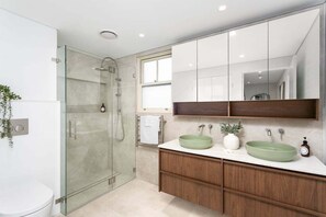 A modern bathroom with a glass-enclosed shower, a white toilet, and a vanity with two green sinks. - FITZ2 - Kirribilli Comfort | 2-Bed Apartment With Harbour Views (Kirribilli)