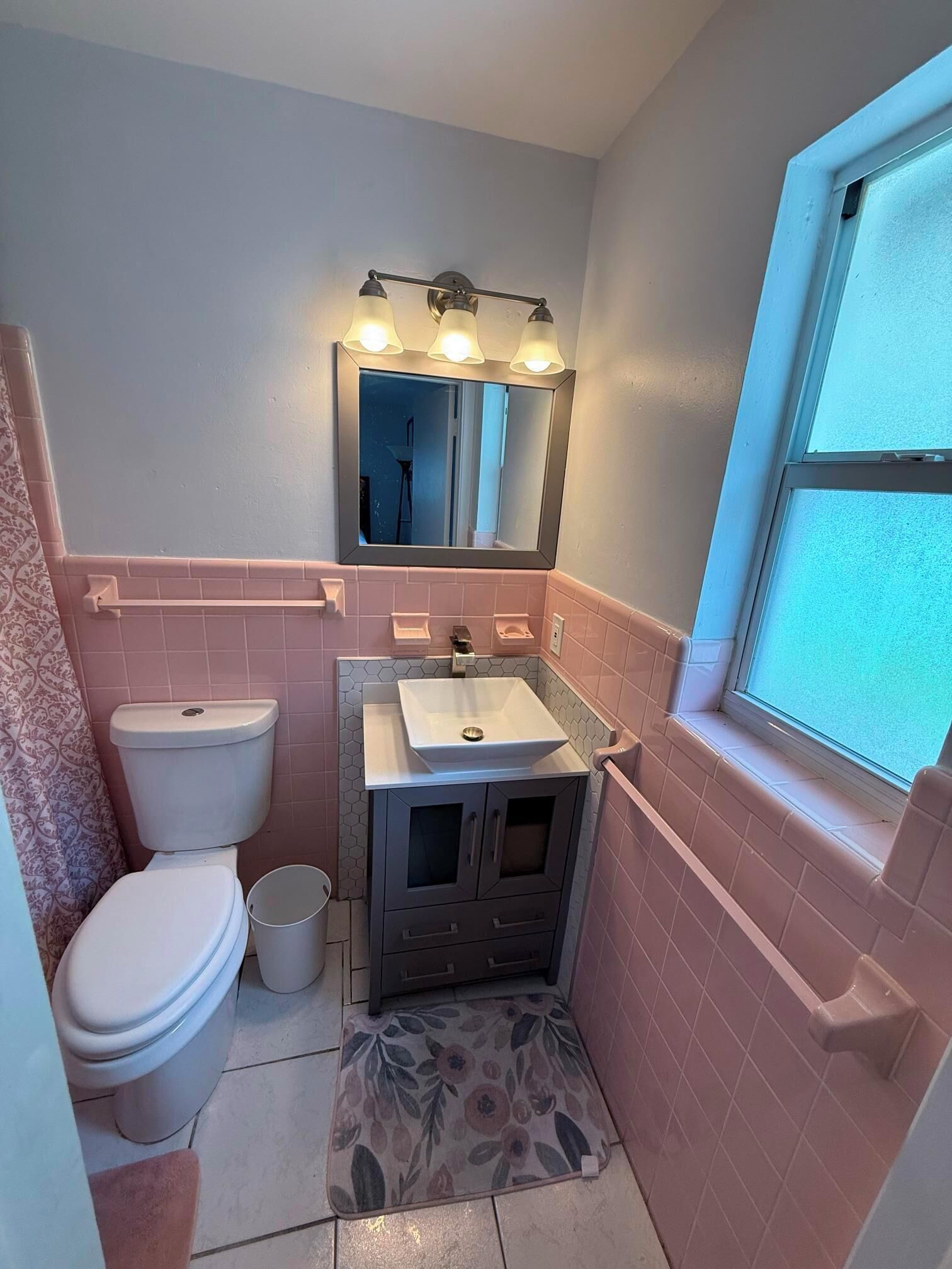 A compact bathroom with a toilet, sink, and mirror.
