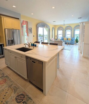 A spacious kitchen with a central island, built-in appliances, and a view to a living area. -  Pristine 6 bed 6 bath villa in the islands premier gated community!!! (Christiansted)