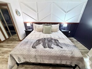 A hotel room with a bed, nightstands, lamps, a clock, and a geometric wall design. - 2bd/2bth/3Pools/BearSightings (Gatlinburg)