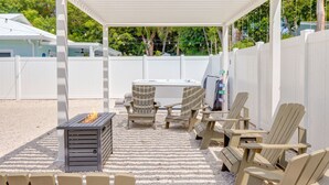 An outdoor patio with Adirondack chairs, a fire pit, and a hot tub. - Isla Ohana: Key Largo, Jacuzzi, Private Yard, Playset, BBQ (Key Largo)