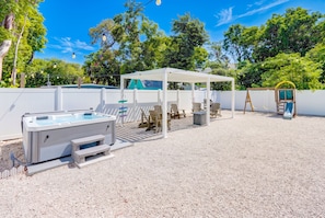 A backyard with a hot tub, outdoor seating, and a swing set. - Isla Ohana: Key Largo, Jacuzzi, Private Yard, Playset, BBQ (Key Largo)