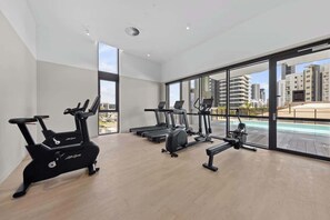 Ein Fitnessraum mit Cardiogeräten, einem Rudergerät und einer Bank.