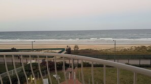 Un balcon avec vue sur la plage et l’océan.