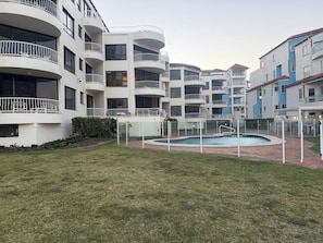 Un immeuble résidentiel doté de nombreux balcons et d’une piscine.