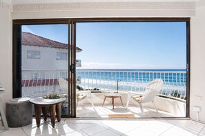 A balcony with a view of the ocean, a table, two chairs, and a small round table. - Mykonos Absolute Beachfront Apt Parking Ocean Views Pets Welcome (Surfers Paradise)