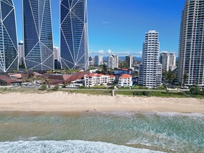 Eine Küstenstadt mit modernen Hochhäusern, Strandhäusern und einem Sandstrand.