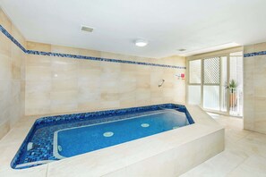 A spa area with a large bathtub, tiled walls, and a window with a view. - 3BR Opposite Burleigh Beach  Pool  Car Park (Burleigh Heads)