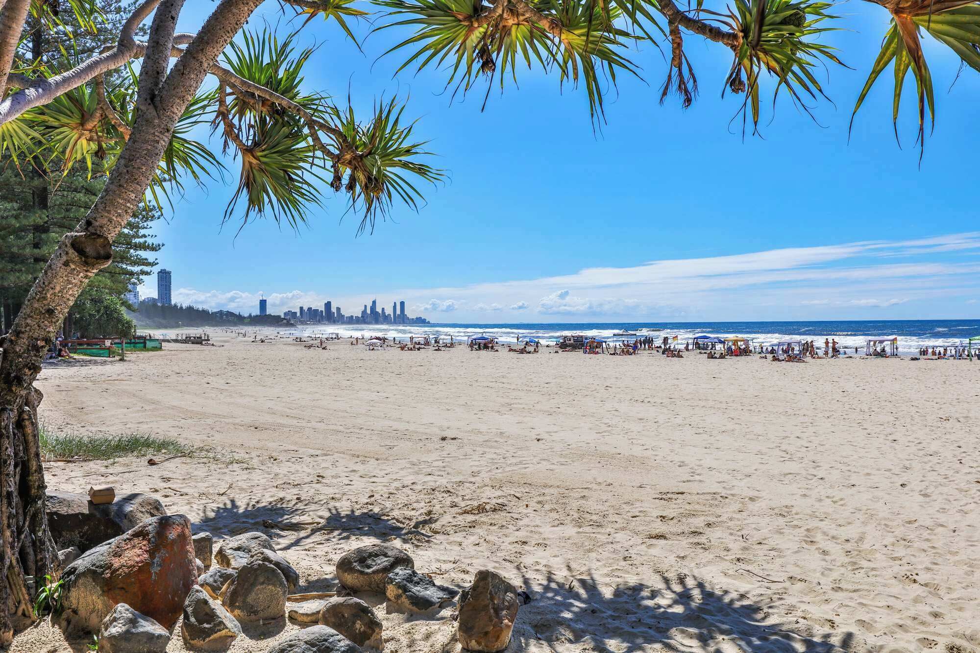 A beach with a clear view of the city skyline in the distance.