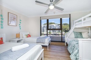 A modern bedroom with a bed, a desk, a bunk bed, and a ceiling fan. - 3BR Opposite Burleigh Beach  Pool  Car Park (Burleigh Heads)