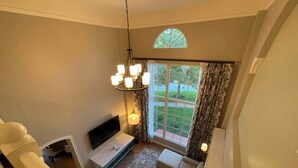 Un salon moderne avec un canapé, un téléviseur et un tapis à motifs.