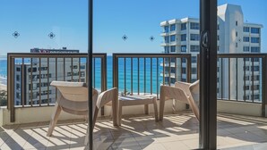 A balcony with a view of the ocean and a building in the background. - Lvl 15 Sunrise + Sunset Views | Pool + Parking (Surfers Paradise)