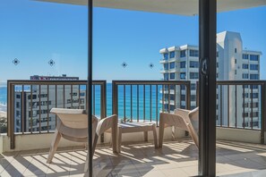 A balcony with a view of the ocean and a building in the background. - Lvl 15 Sunrise + Sunset Views | Pool + Parking (Surfers Paradise)