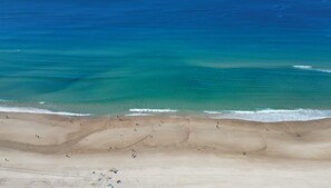 A beach with clear blue waters and a sandy shore. - Lvl 15 Sunrise + Sunset Views | Pool + Parking (Surfers Paradise)